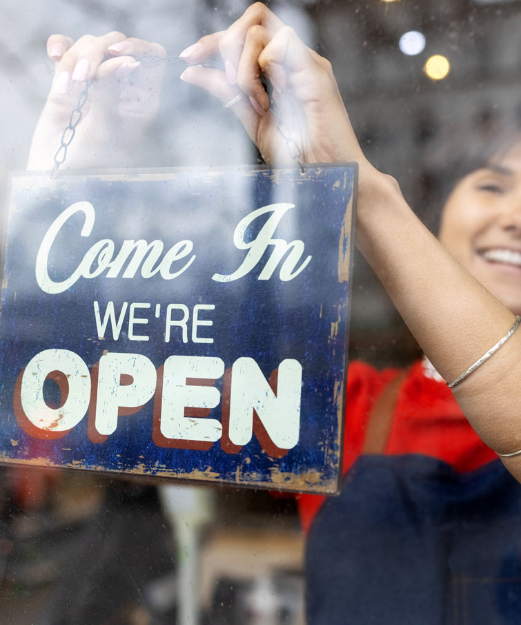 Women hanging open sign