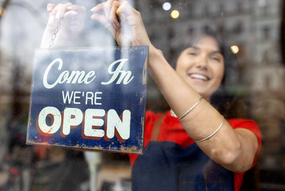 Woman hanging an open sign